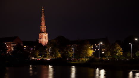 Copenhagen-Night-Cityscape-with-Illuminated-Baroque-Spire-Church-Reflection